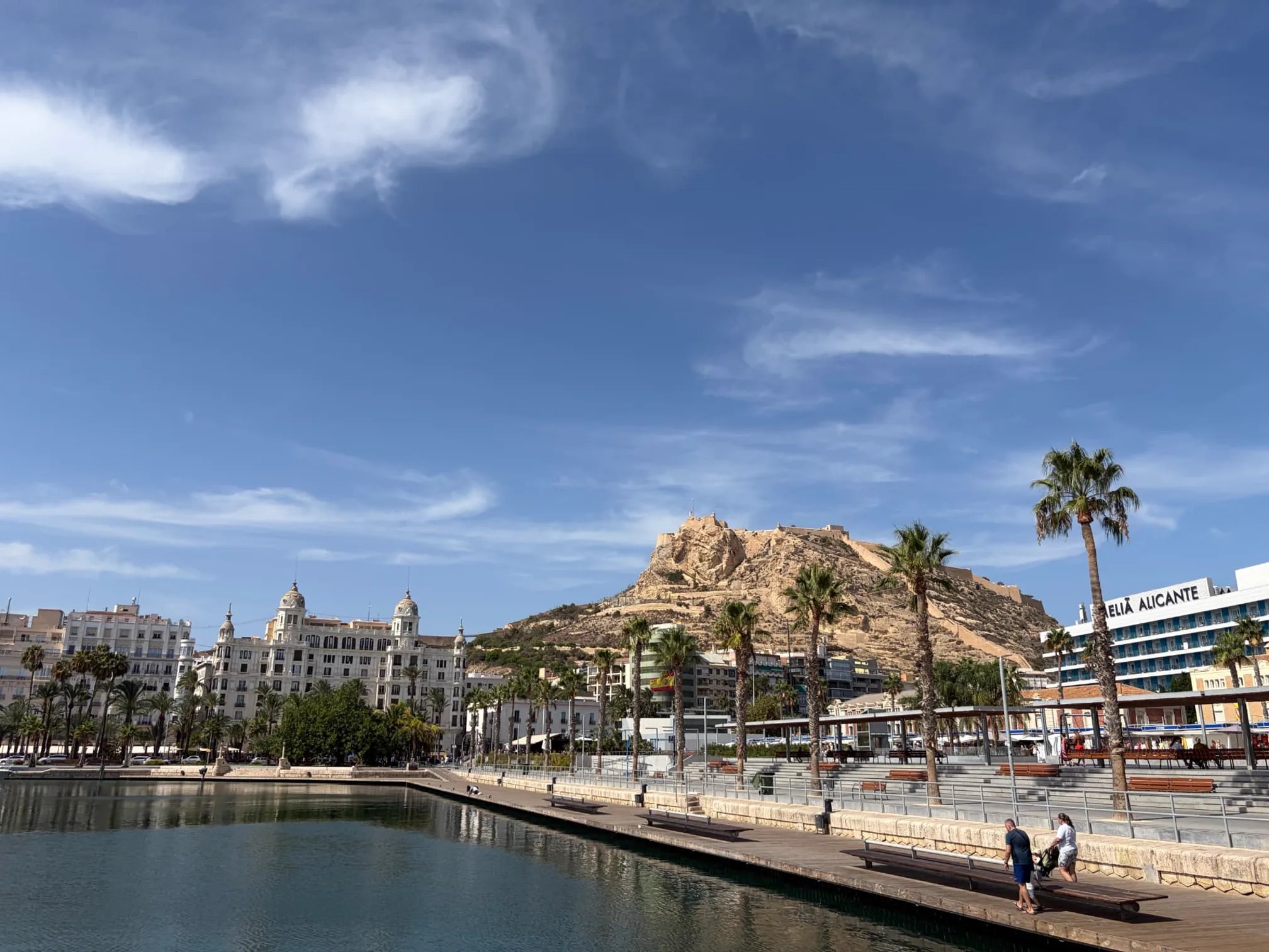 Alicante harbor with Santa Bárbara castle, palm trees and waterfront promenade